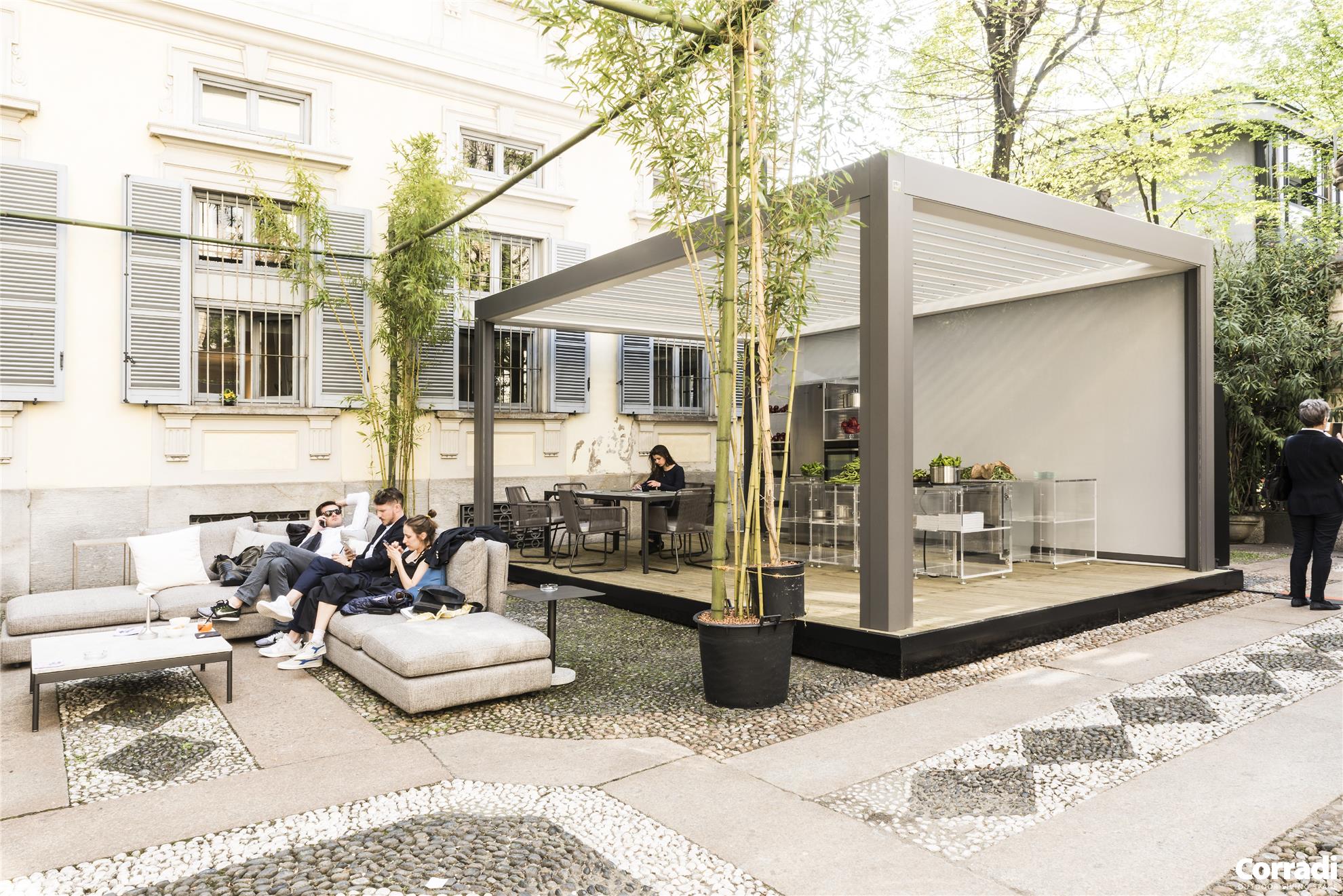 Pergola bioclimatique en aluminium verandair installée dans la cour extérieure d'une bâtisse blanche