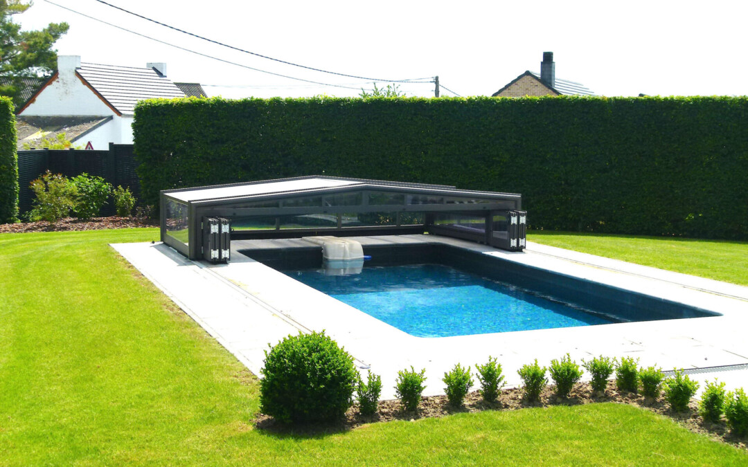 Abri de piscine bas amovible dans un jardin vert et bien entretenu