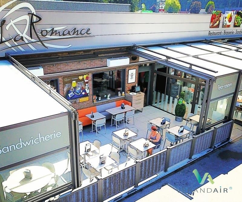 terrasse du restaurant La Romance couverte par une véranda rétractable à demi ouverte