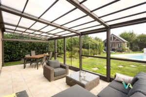 Véranda rétractable avec mobilier de jardin et vu sur la piscine