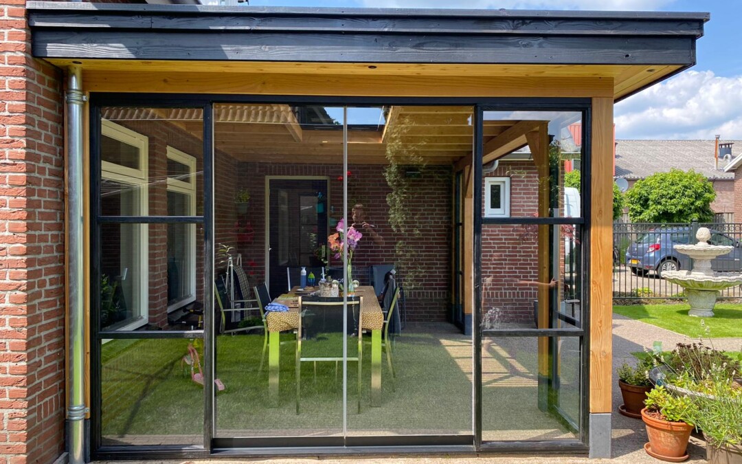 Pergola en bois qui est adossée au mur du maison en briques rouges