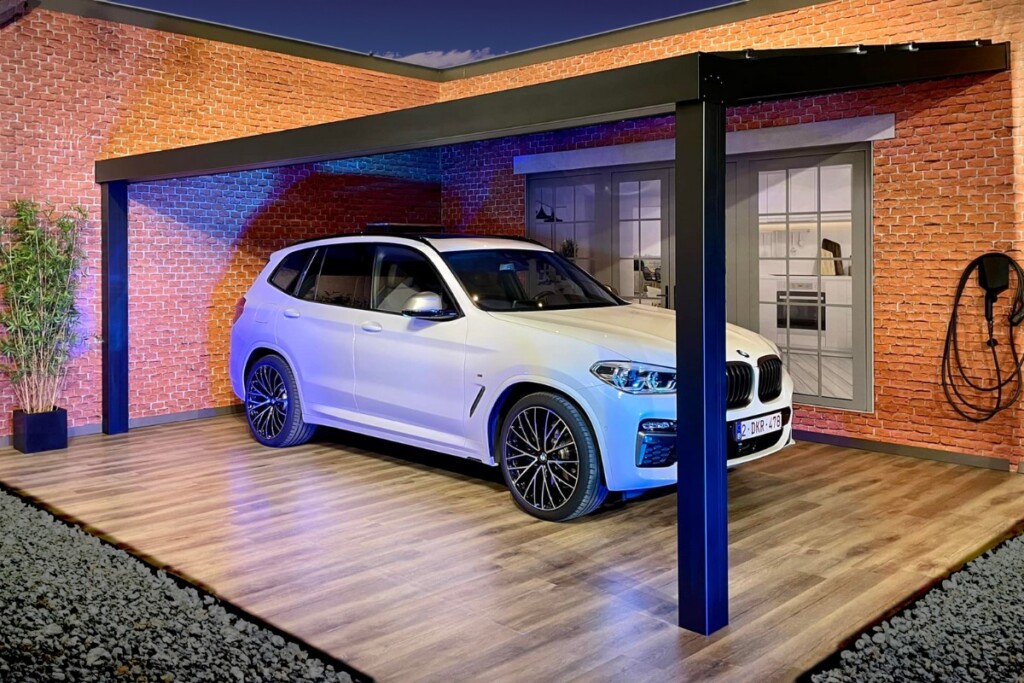 Voiture 4x4 blanche stationnée sous un carport Verandair de nuit. 