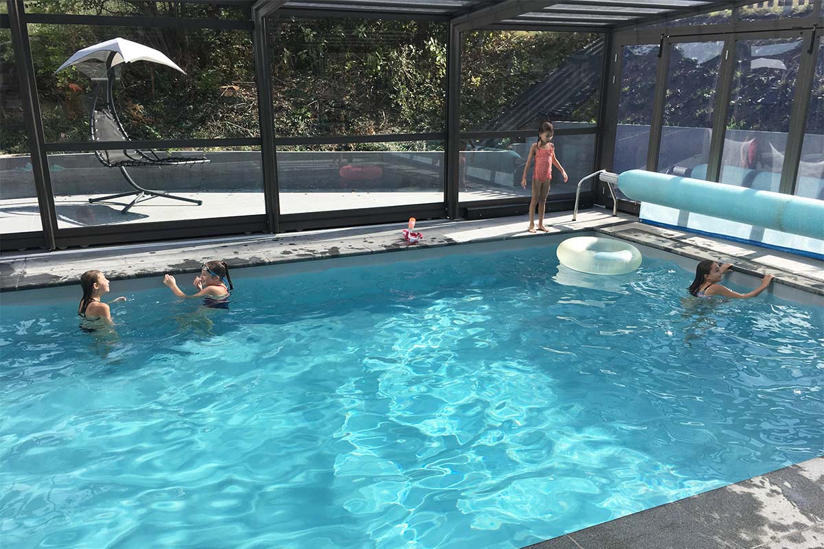 Abri de piscine haut avec des enfants qui jouent dans la piscine