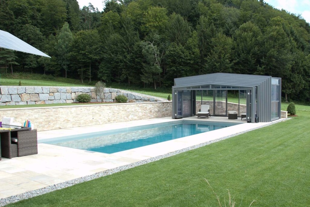 Abri de piscine haut amovible avec transats et vue sur le jardin