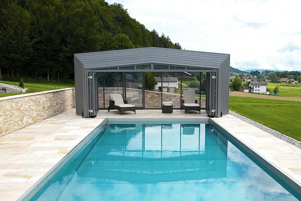 Abri de piscine haut amovible avec transats et vue sur le jardin