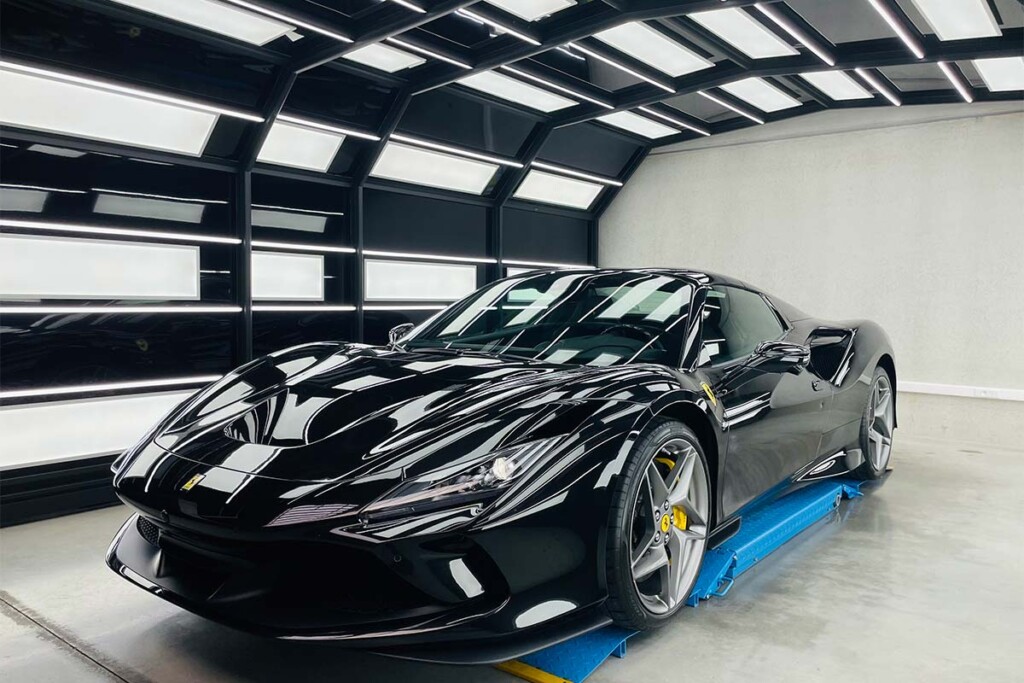 Tunnel Genius. Tunnel de lumière rétractable avec une Ferrari noire brillante en dessous