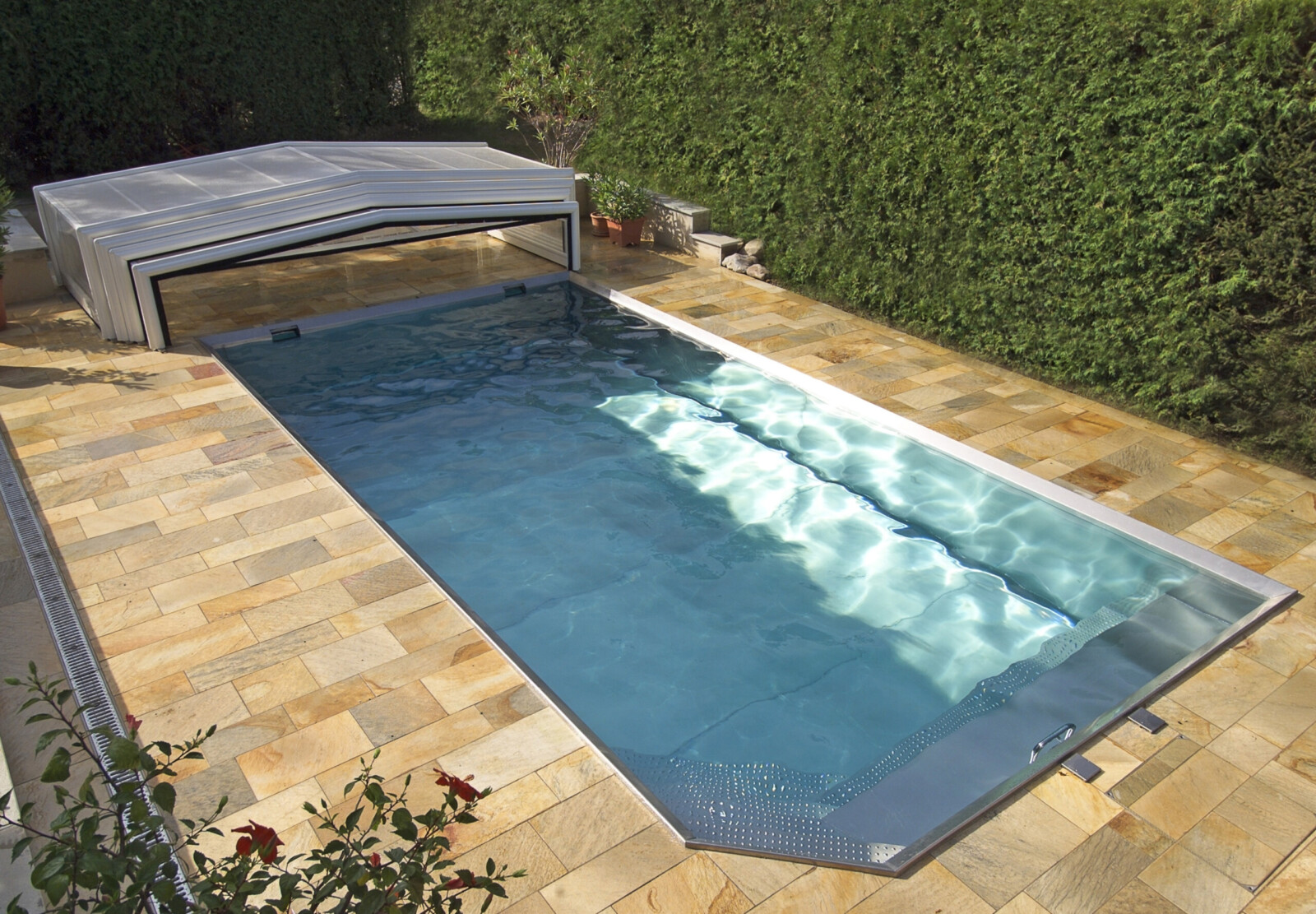 Abri de piscine amovible blanc pour une piscine entourée de carrelages beiges