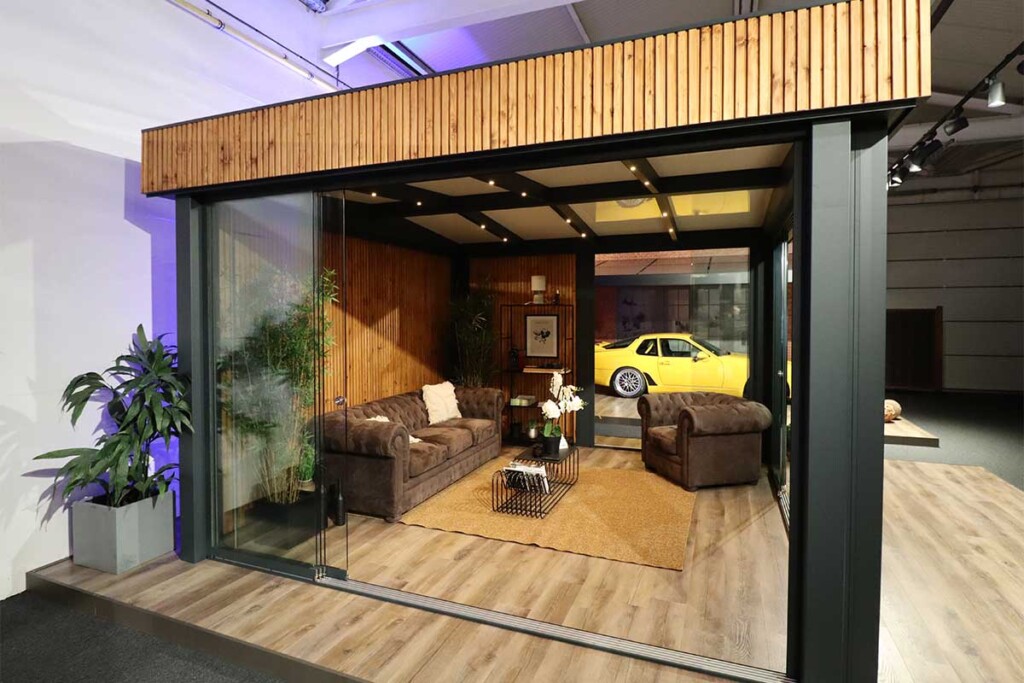 Pool House structure en aluminium et bois de qualité supérieur dans un showroom Verandair vu de côté avec une voiture de sport jaune dans le fond