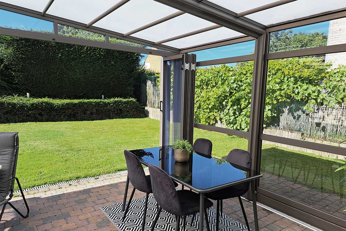 Abri de terrasse rétractable avec vue sur le jardin, chaises et table