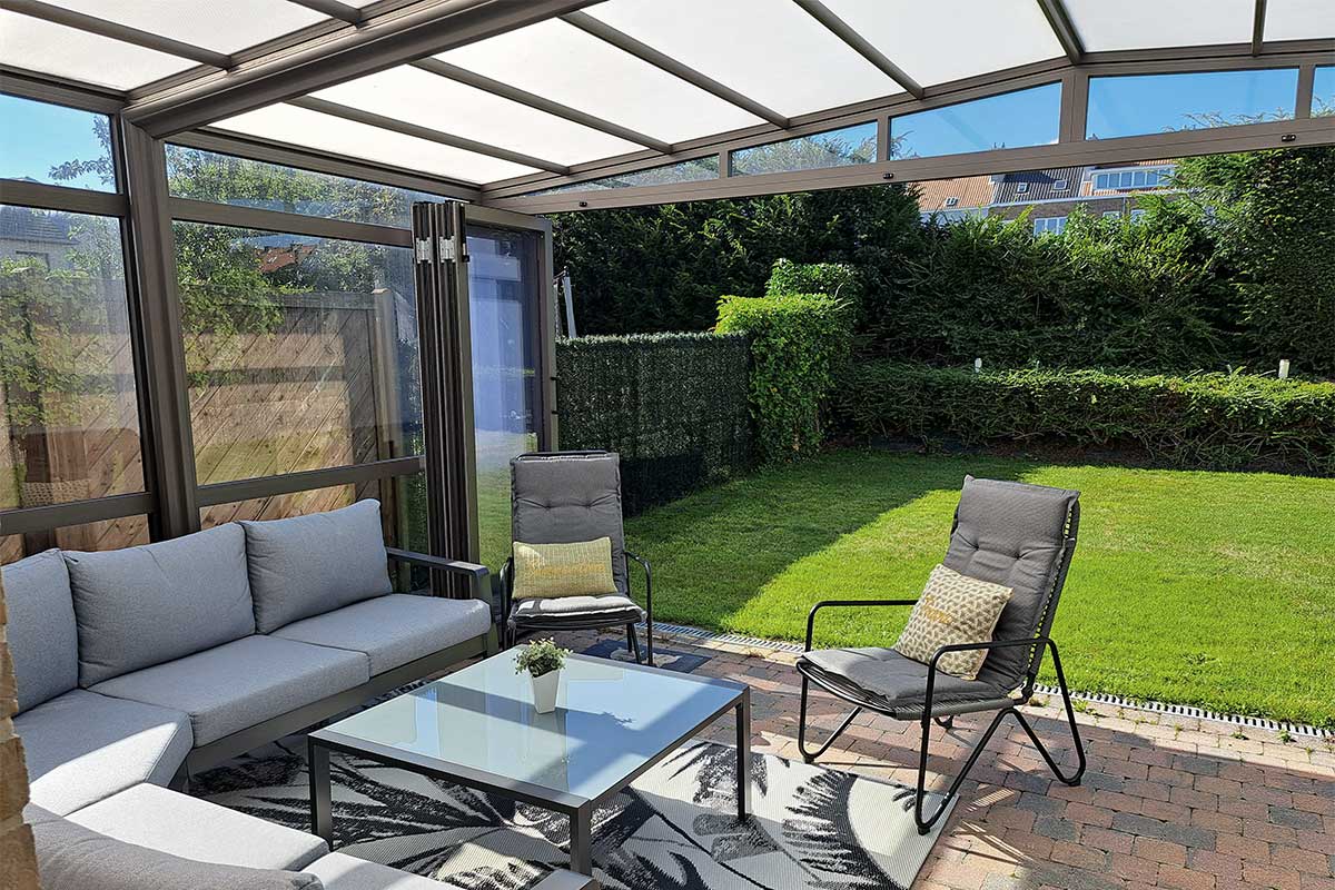 Abri de terrasse rétractable avec vue sur le jardin, fauteuils et table