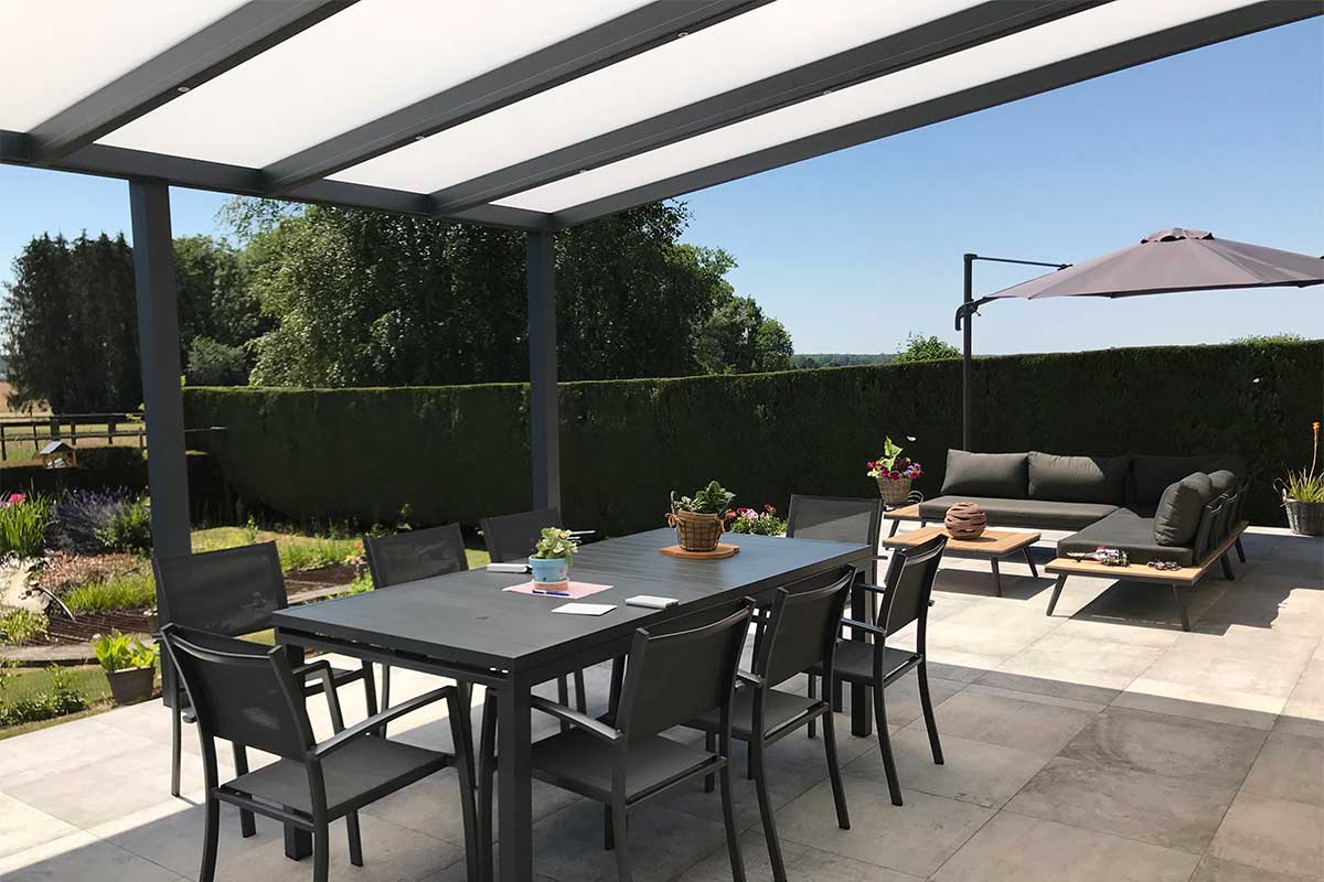 Pergola toit fixe ouverte sur une terrasse avec une table, des chaises