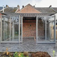 Abri de terrasse rétractable gris sur une terrasse en pavés